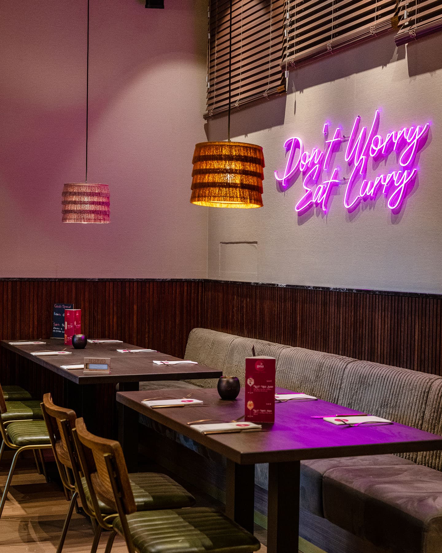 Gastraum des indischen Restaurants GOA HafenCity mit Neon-Schriftzug „Don’t Worry Eat Curry“