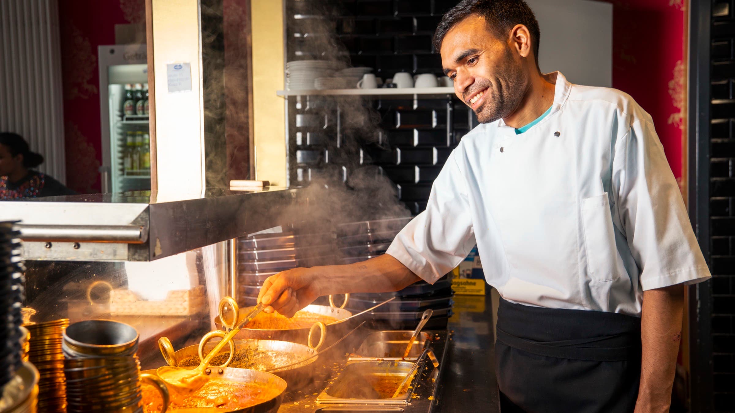 Koch bereitet indische Gerichte in der offenen Küche des GOA Restaurant Hamburg zu